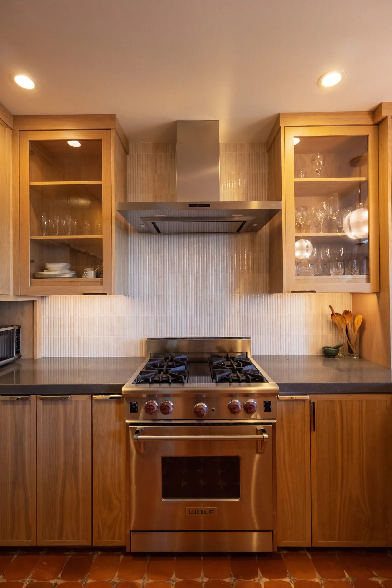 Rift oak kitchen with glass-front uppers, handmade tile backsplash and a Wolf range